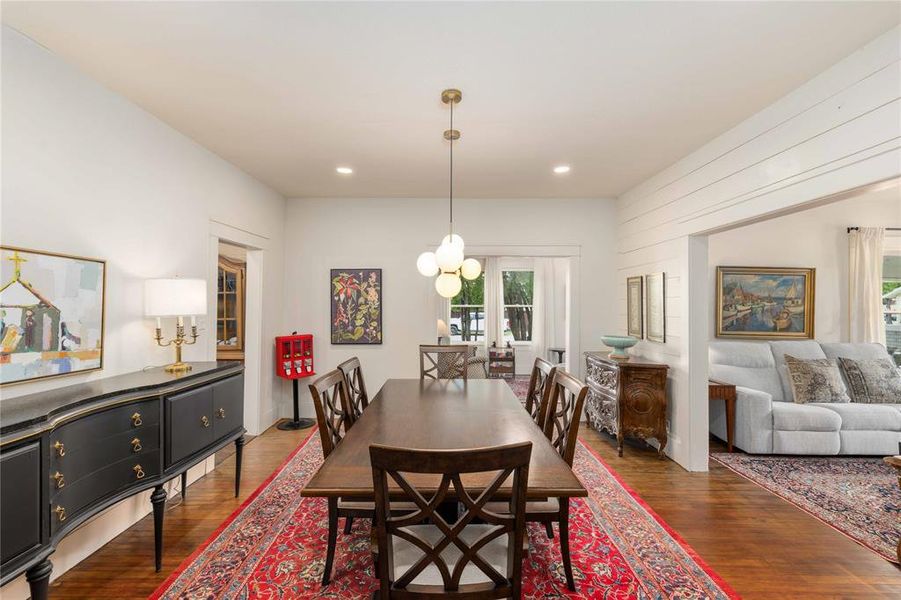 Hardwood-style flooring throughout, featuring an open-concept layout with white painted walls and a shiplap accent wall