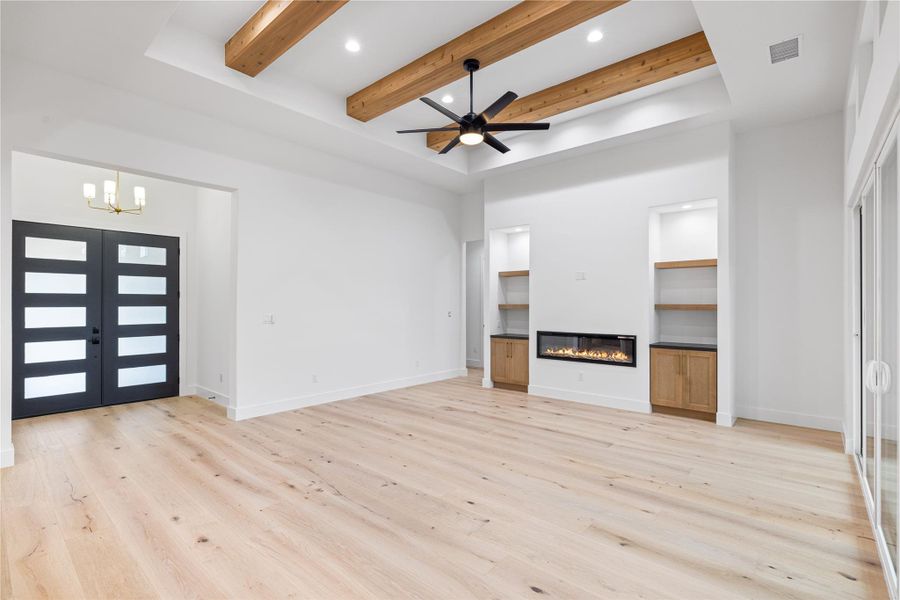 Living room with engineered white oak wood floors, beam ceiling, electric fireplace, and ceiling fan Living room with engineered white oak wood floors, beam ceiling, electric fireplace, and ceiling fan