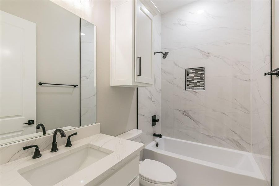 Full bath with toilet, vanity, and bathing tub / shower combination Full bath with toilet, vanity, and bathing tub / shower combination