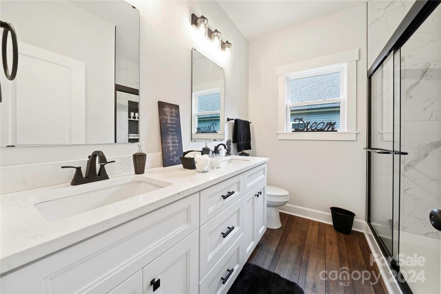 Main Bath with quartz double vanities, shaker cabinets & vinyl plank floor.