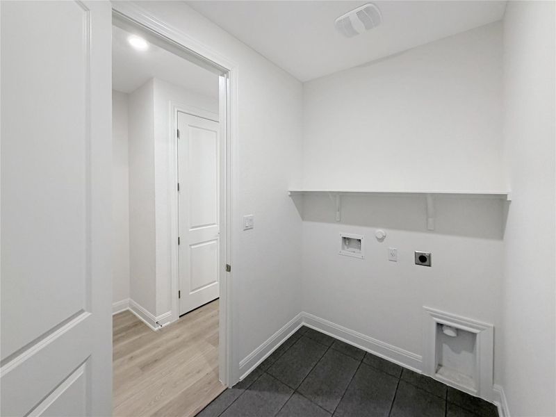 Laundry area featuring electric dryer hookup, dark tile patterned flooring, hookup for a gas dryer, and washer hookup