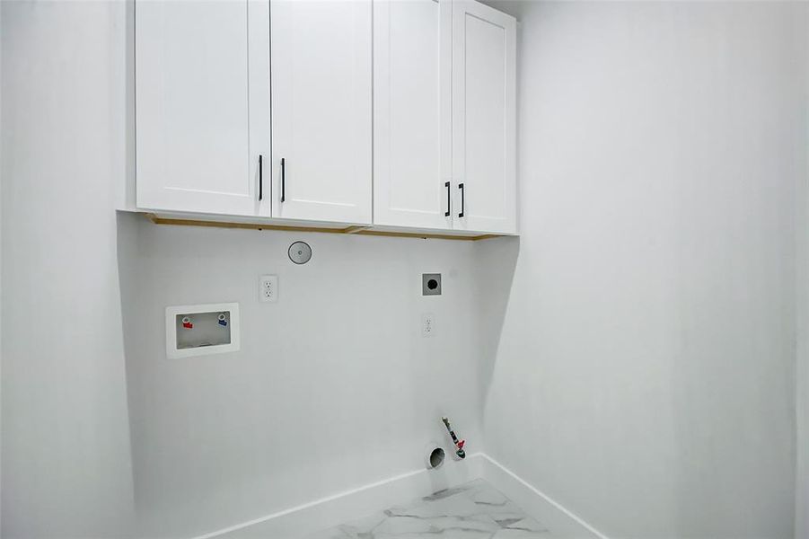 Utility room with both electric and natural gas as well as beautiful cabinetry