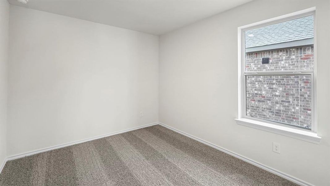 Room featuring light gray patterned carpet, white baseboards, and a single-pane window with white trim