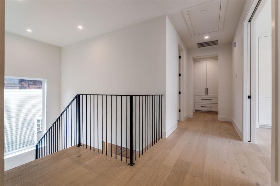 Corridor featuring recessed lighting, attic access, visible vents, light wood-style floors, and an upstairs landing Corridor featuring recessed lighting, attic access, visible vents, light wood-style floors, and an upstairs landing