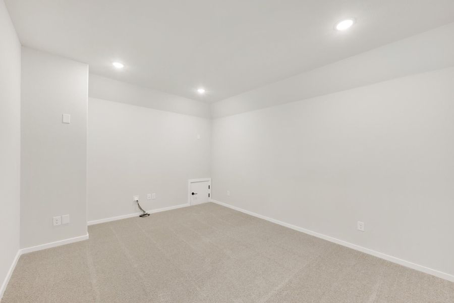 Empty room with white walls, beige carpet, recessed lighting, and a small door panel on the back wall. Empty room with white walls, beige carpet, recessed lighting, and a small door panel on the back wall.
