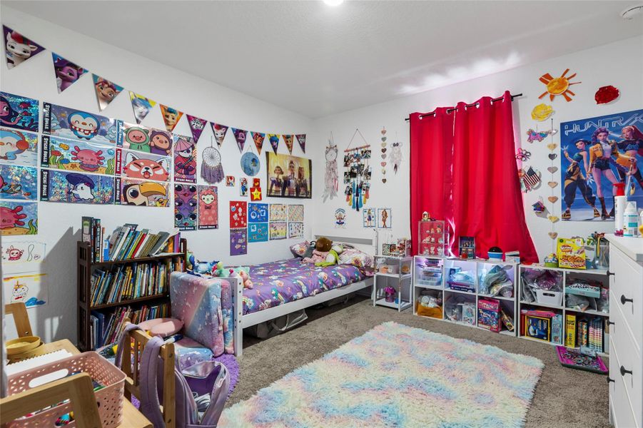 A well-lit bedroom with ample storage and a cozy floor rug invites relaxation.
