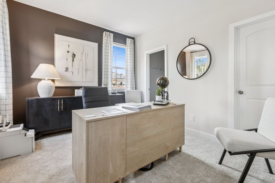 A room with a desk and chairs.