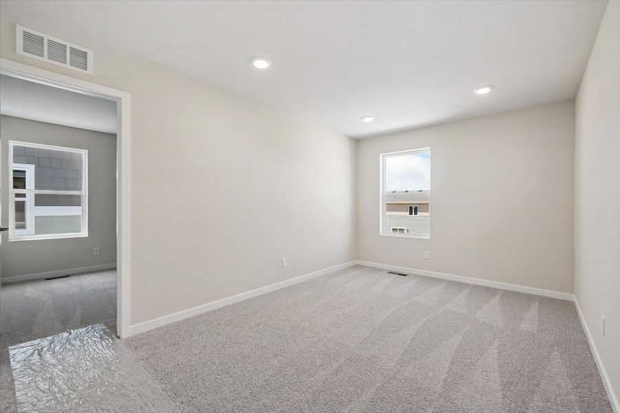 A room with a carpet and a window.