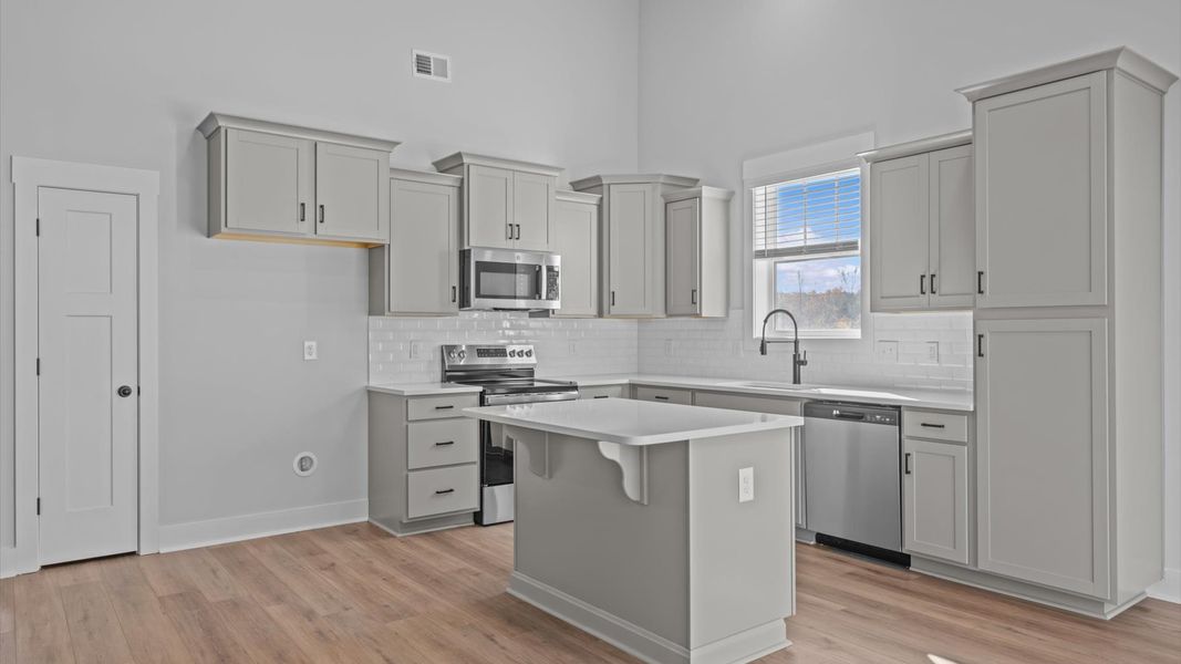 Superior craftsmanship shines in this modern kitchen with a space-saving island and open flow