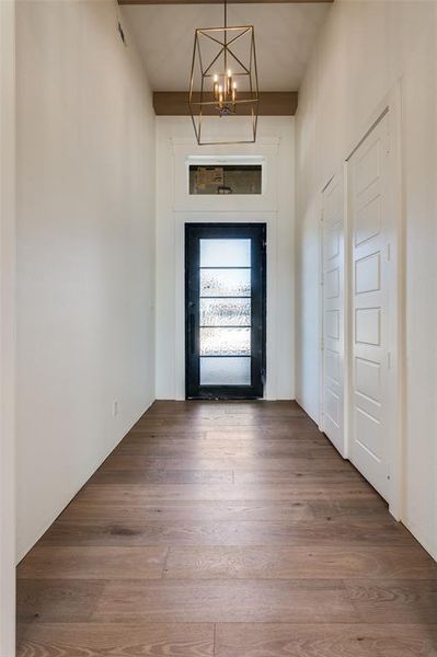 View of entry with champagne bronze fixture, white oak beams, and custom iron door. View of entry with champagne bronze fixture, white oak beams, and custom iron door.