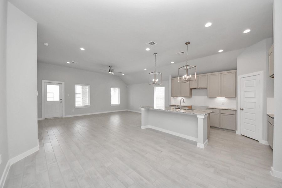 Relax and unwind in this inviting family room, illuminated by abundant natural light streaming in through tall windows, complemented by high ceilings and stunning flooring. Stay comfortable year-round with the gentle breeze from the ceiling fan, creating the perfect atmosphere for family gatherings.