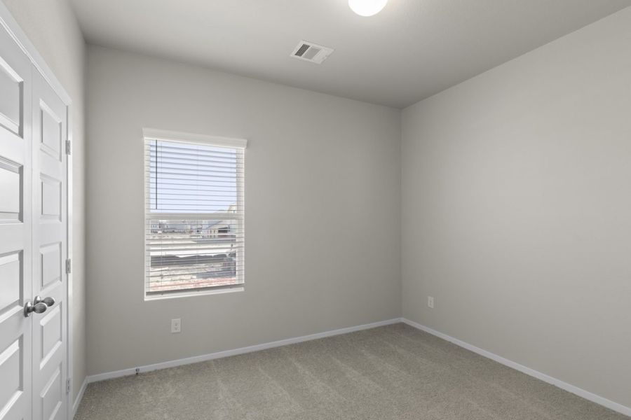 Image of a bedroom with beige walls, tan carpeting, white trim and a window with blinds Image of a bedroom with beige walls, tan carpeting, white trim and a window with blinds