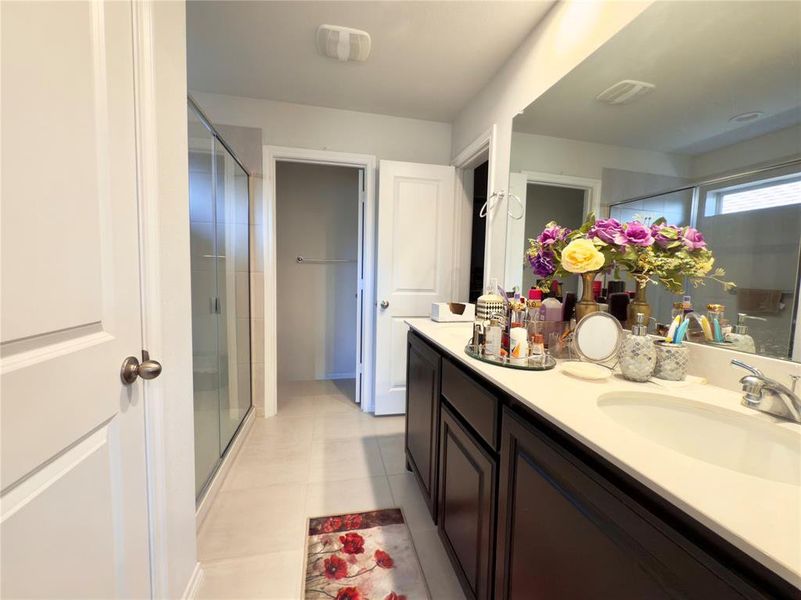 Bathroom with a stall shower, vanity, and light tile patterned floors Bathroom with a stall shower, vanity, and light tile patterned floors