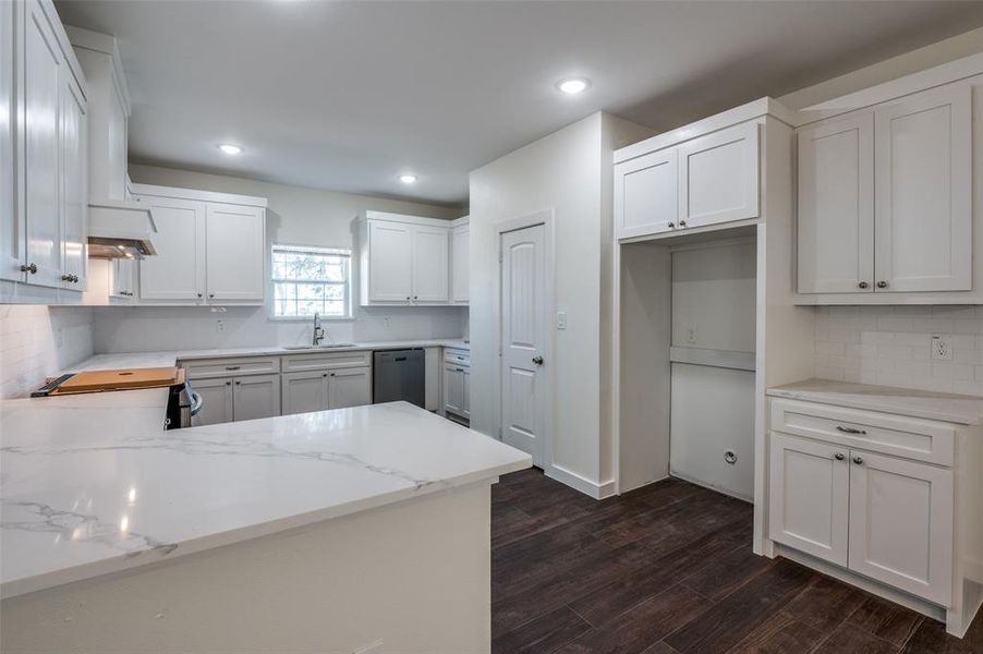 Kitchen with sink, electric stove, white cabinets, and dark hardwood / wood-style flooring