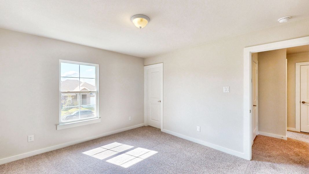 A room with a window and a carpet.