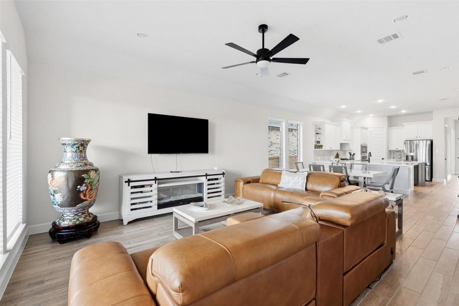 Open-concept living space featuring wood-finish flooring, recessed lighting, and a contemporary ceiling fan