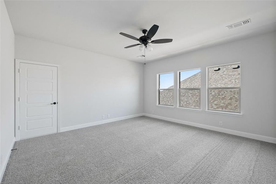 Spare room featuring light carpet and a ceiling fan