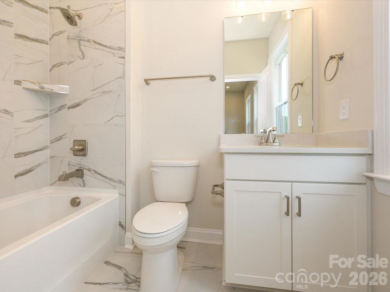 Secondary bathroom with tiled walls above the tub