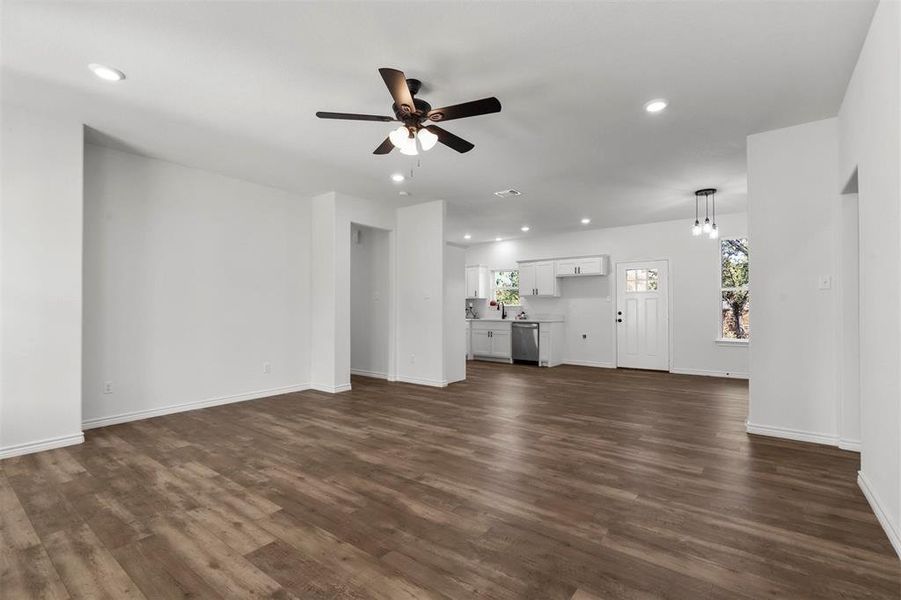 Unfurnished living room with dark hardwood / wood-style floors and ceiling fan