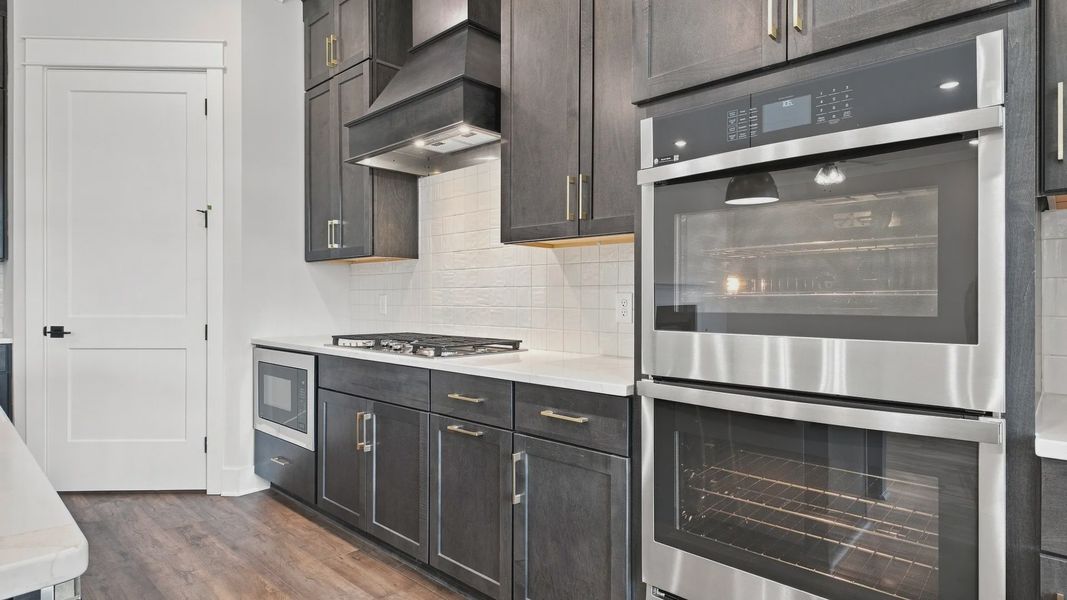 Kitchen essentials such as oven, stovetop, ad drawers with a white tile backdrop for a more elevated design.
