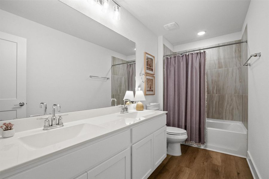 Bright and spacious upstairs full bath featuring a dual-sink vanity, generous counter space, and a tub/shower combination.