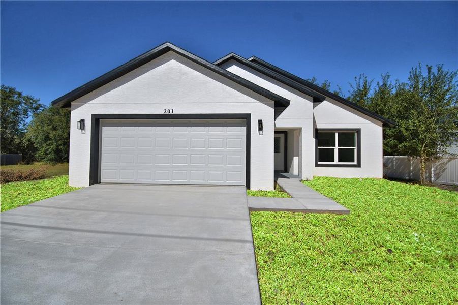 Front exterior of a new home in , Poinciana, FL, highlighting curb appeal (Image 1). Front exterior of a new home in , Poinciana, FL, highlighting curb appeal (Image 1).