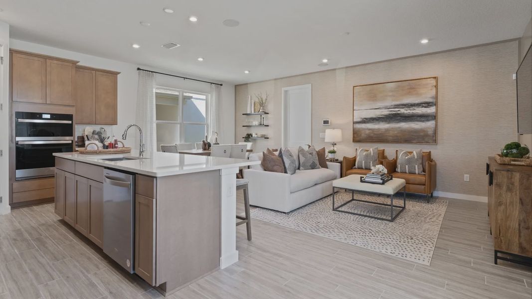 Open main floor kitchen, family room and cafe in a DRB Home Clementine model at the Trinity Place community.