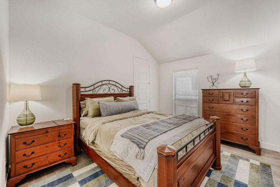 Bedroom with lofted ceiling and light wood-style flooring