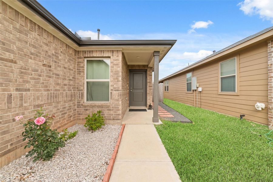 Covered front entry with a window that brings in soft natural light and a welcoming approach to the home.