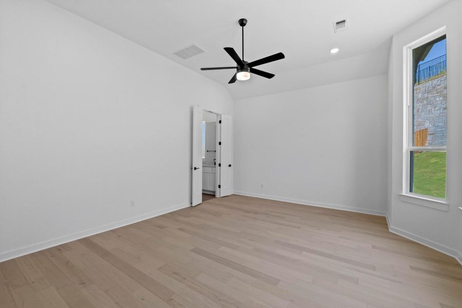 Empty room with plenty of natural light, light wood-style floors, ceiling fan, and lofted ceiling