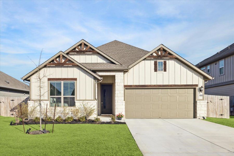 View of front of home with driveway, roof with shingles, fence, a front lawn, and board and batten siding