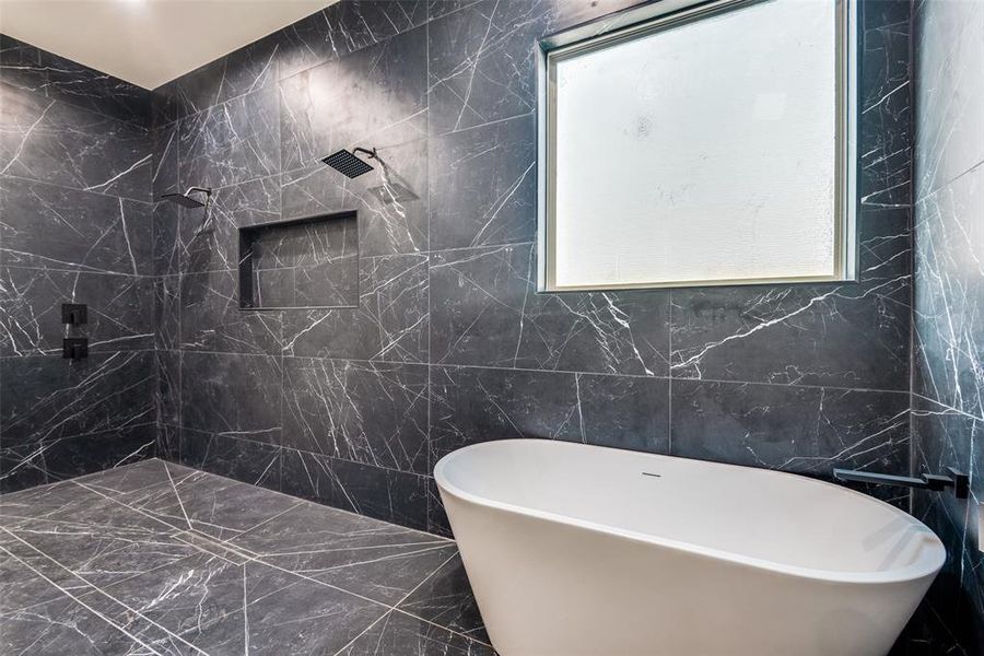 Full bath with a freestanding tub, tile walls, a marble finish shower, and marble finish flooring