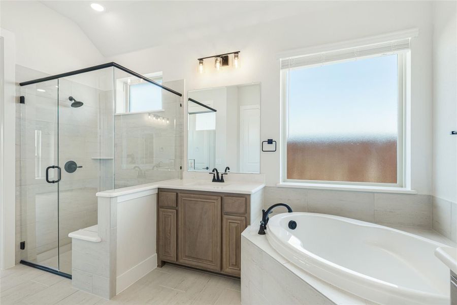 Master bathroom with glass walk-in shower, soaking tub, and wood vanity with white countertop Master bathroom with glass walk-in shower, soaking tub, and wood vanity with white countertop