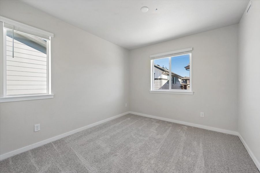 A room with a window and a carpet.