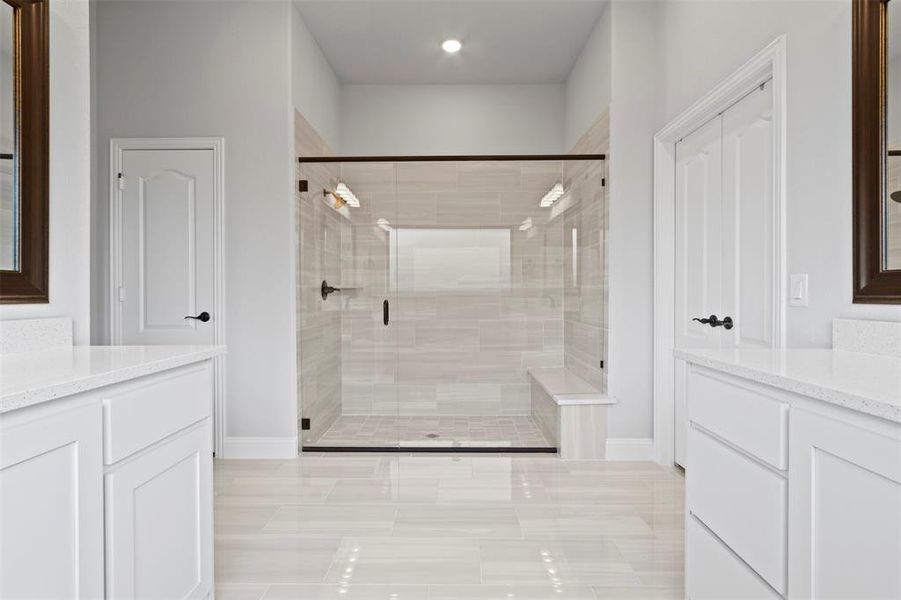 Bathroom featuring tile patterned floors, vanity, and walk in shower