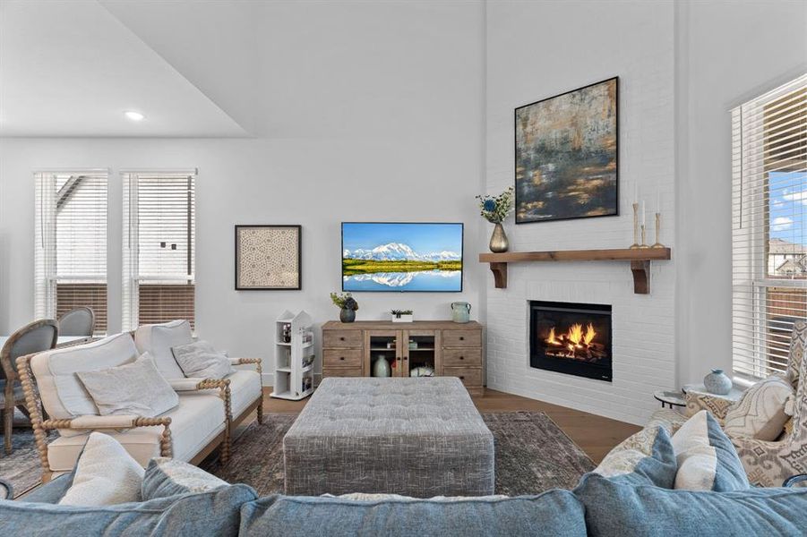 Your casual living room unfolds with a dramatic 2-story ceiling that adds volume & light while still feeling warm & inviting. The space is centered around a gas log fireplace that serves as both a visual anchor & a cozy gathering point. Your casual living room unfolds with a dramatic 2-story ceiling that adds volume & light while still feeling warm & inviting. The space is centered around a gas log fireplace that serves as both a visual anchor & a cozy gathering point.