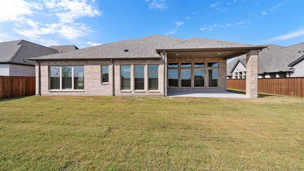 Back of house with a patio and a yard