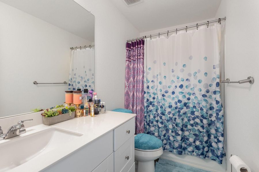 Full bathroom featuring toilet, radiator, shower / tub combo with curtain, and vanity