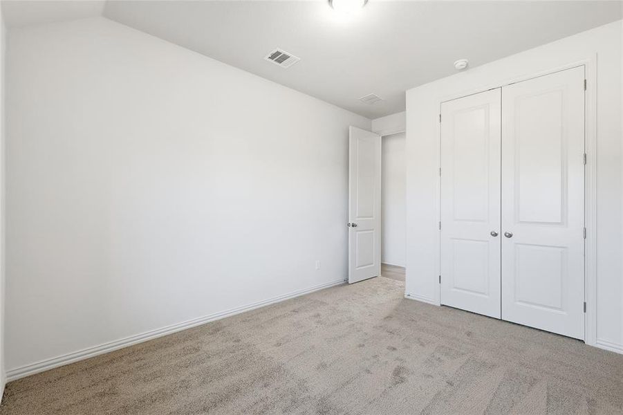 Unfurnished bedroom featuring carpet floors and a closet Unfurnished bedroom featuring carpet floors and a closet