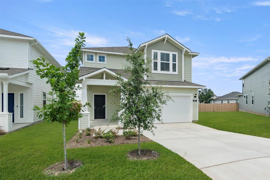 View of front facade featuring concrete driveway, a garage, and roof with shingles
