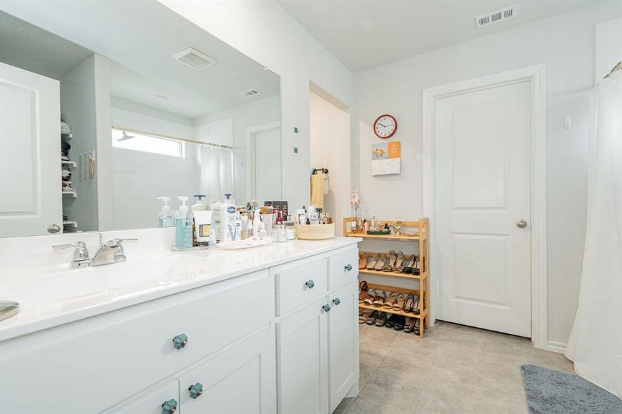 Bathroom with tile patterned floors, visible vents, and vanity