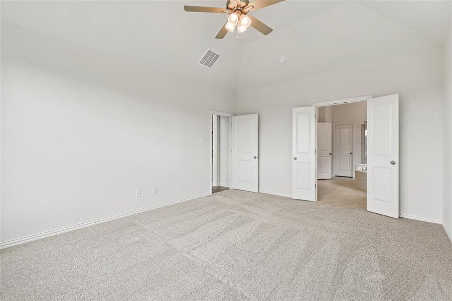 Unfurnished bedroom featuring light colored carpet, high vaulted ceiling, and ceiling fan