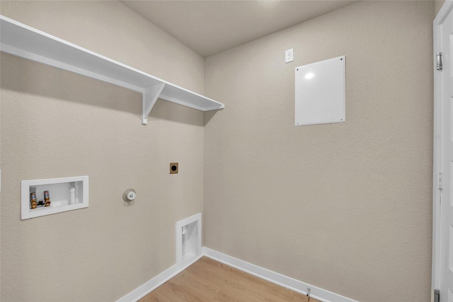 Laundry area featuring hookup for a gas dryer, light wood-style flooring, electric dryer hookup, hookup for a washing machine, and a textured wall