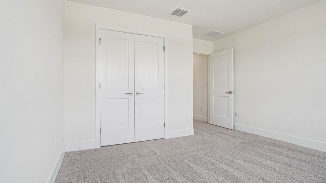 Bedroom with closet in the Plumeria plan at Lakeside at Satilla by DRB Homes. Bedroom with closet in the Plumeria plan at Lakeside at Satilla by DRB Homes.