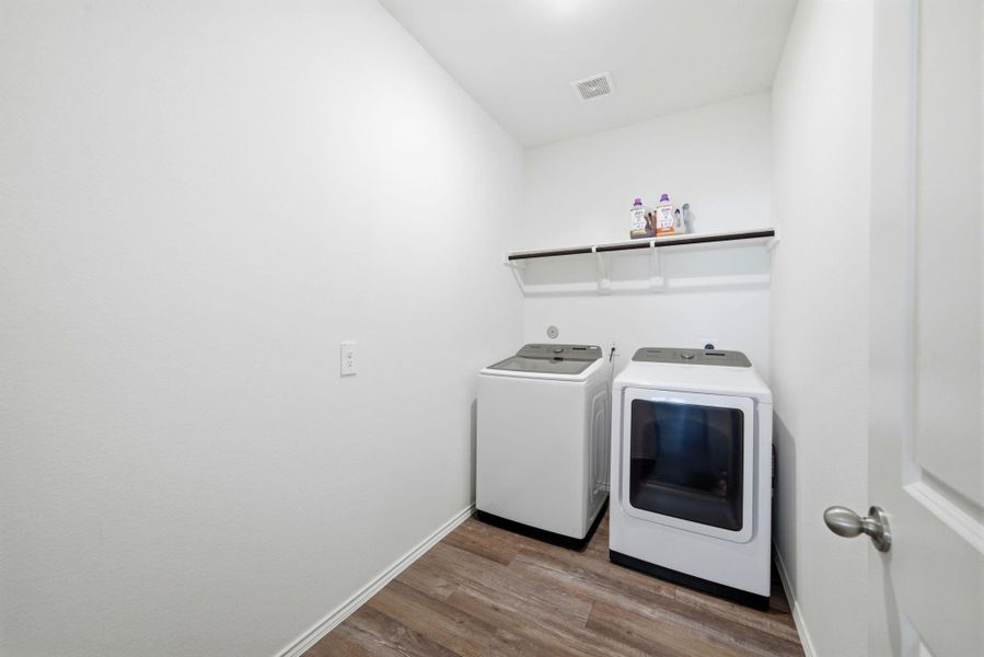 Functional utility space on the lower level: shelving for detergents and a clothes-hanging bar for easy laundry days.