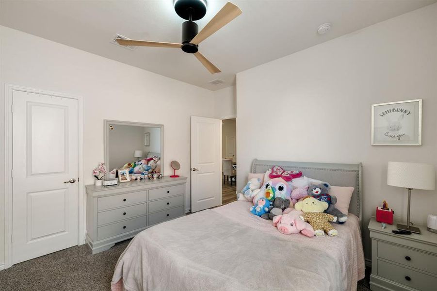 Carpeted bedroom with a ceiling fan Carpeted bedroom with a ceiling fan
