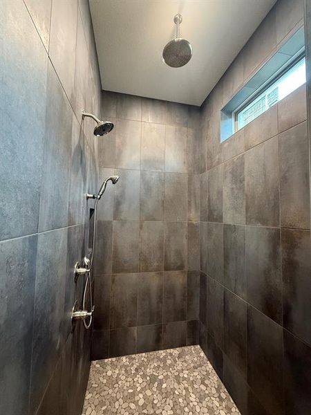 Large walk in shower with rain head and 2 wall shower heads.