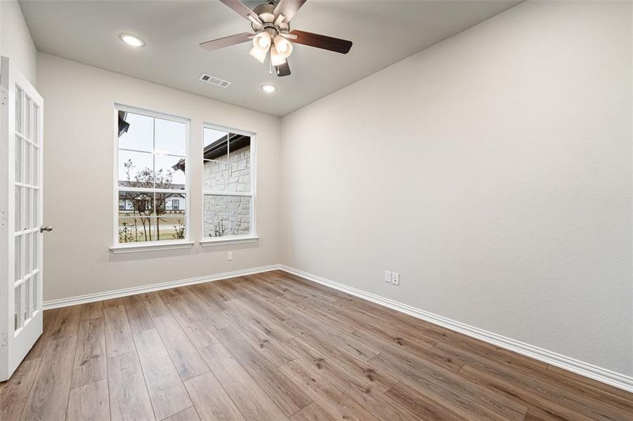 Spare room featuring light wood-style flooring, a ceiling fan, and recessed lighting