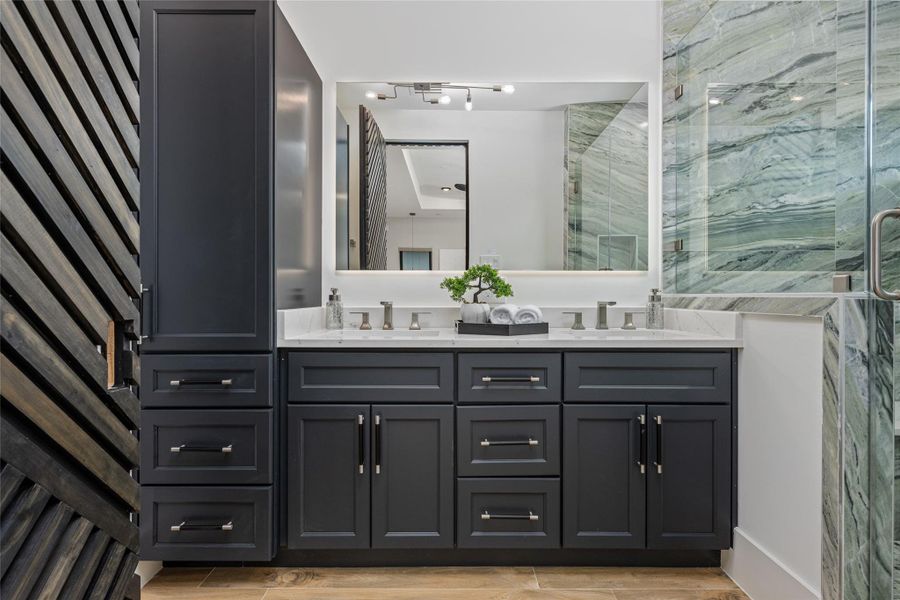 An ultra-luxurious primary bath features dual illuminated mirrors, designer cabinetry, quartz counters, and elegant fixtures An ultra-luxurious primary bath features dual illuminated mirrors, designer cabinetry, quartz counters, and elegant fixtures