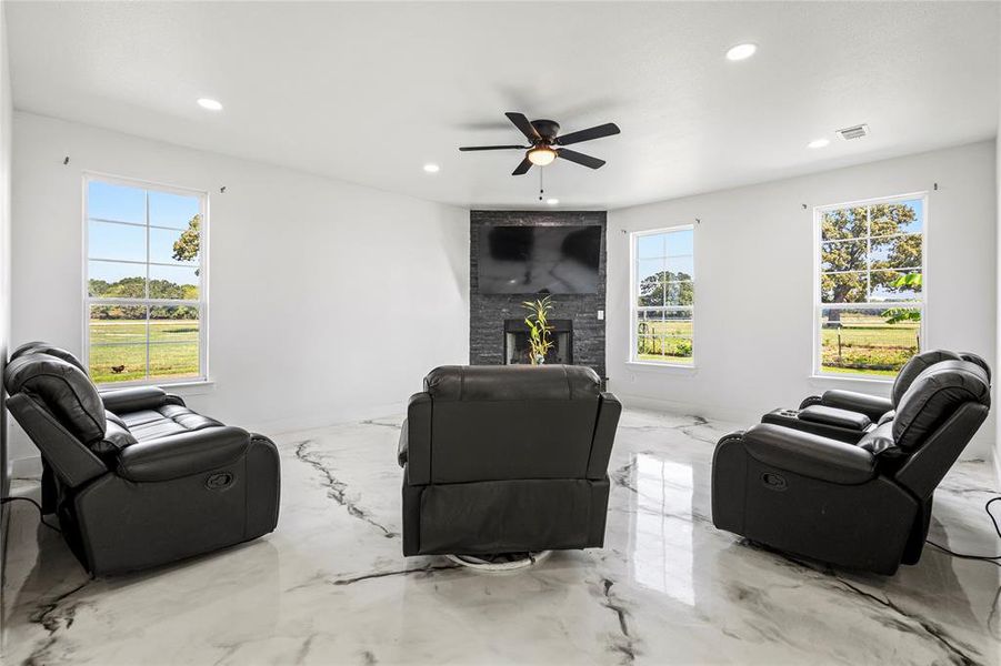 Living area featuring marble tiled floors, a fireplace, recessed lighting, and a ceiling fan Living area featuring marble tiled floors, a fireplace, recessed lighting, and a ceiling fan